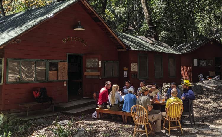 Volunteers working to re-open the Camp gather for lunch outside the historic Lodge.