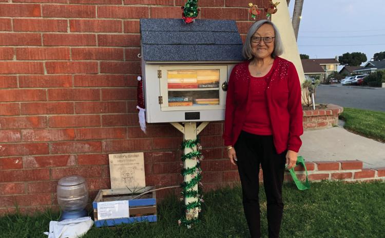 Judy Aoki with the little library she set up across the street from Cox Elementary. Photo by JUDY AOKI / Fountain Valley Living Magazine